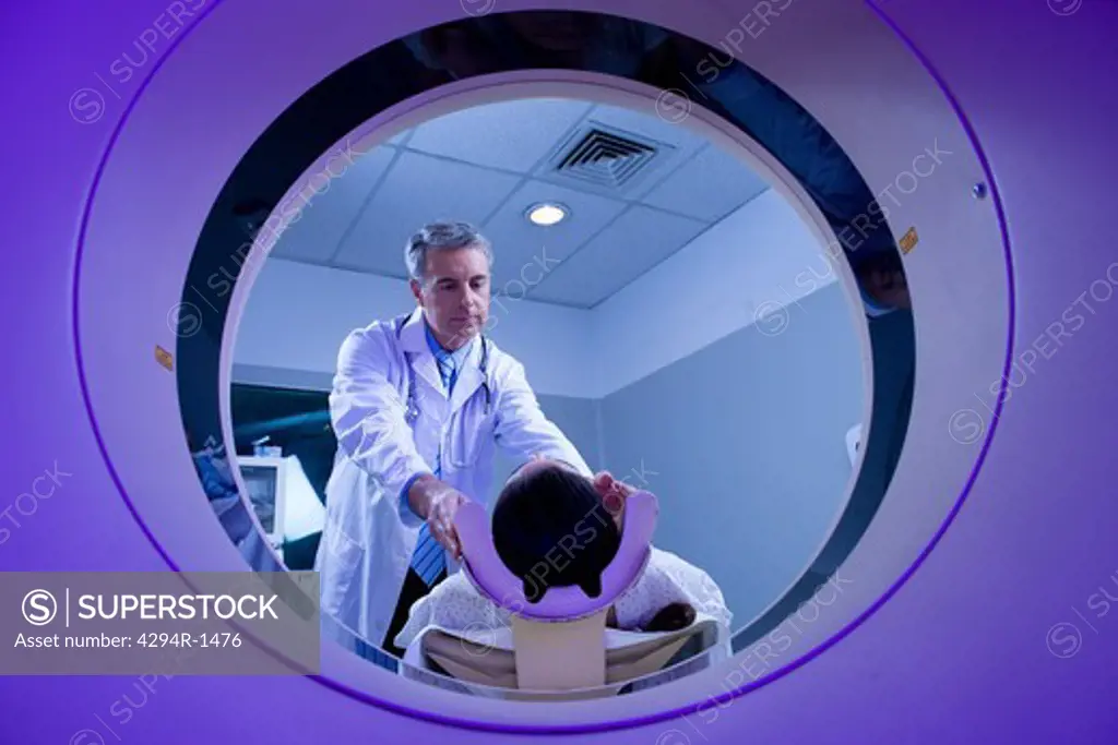 Doctor with patient at CT scanner