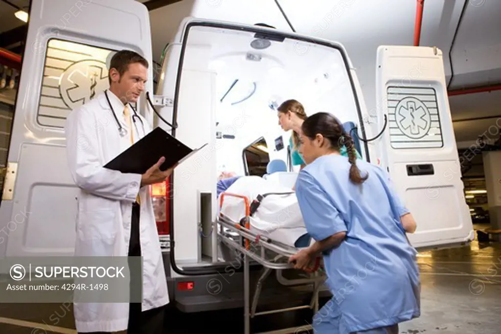 Paramedics with patient at ambulance car