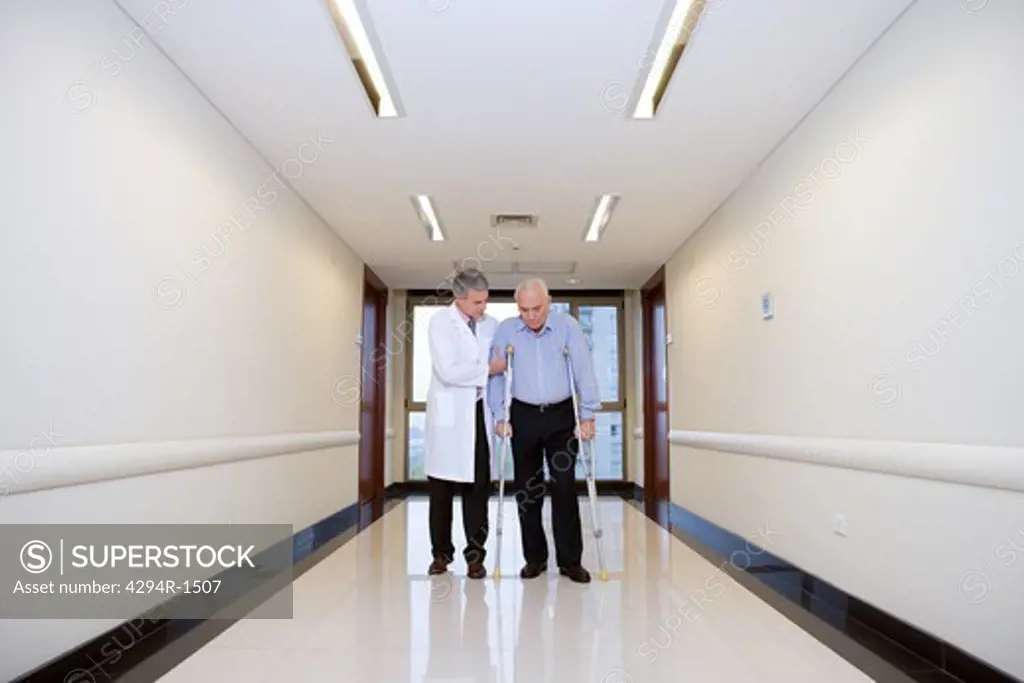 Doctor helping senior man walking
