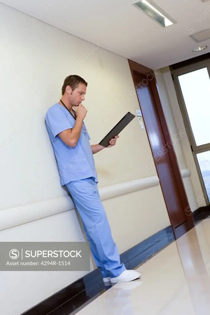 Young doctor looking at clipboard