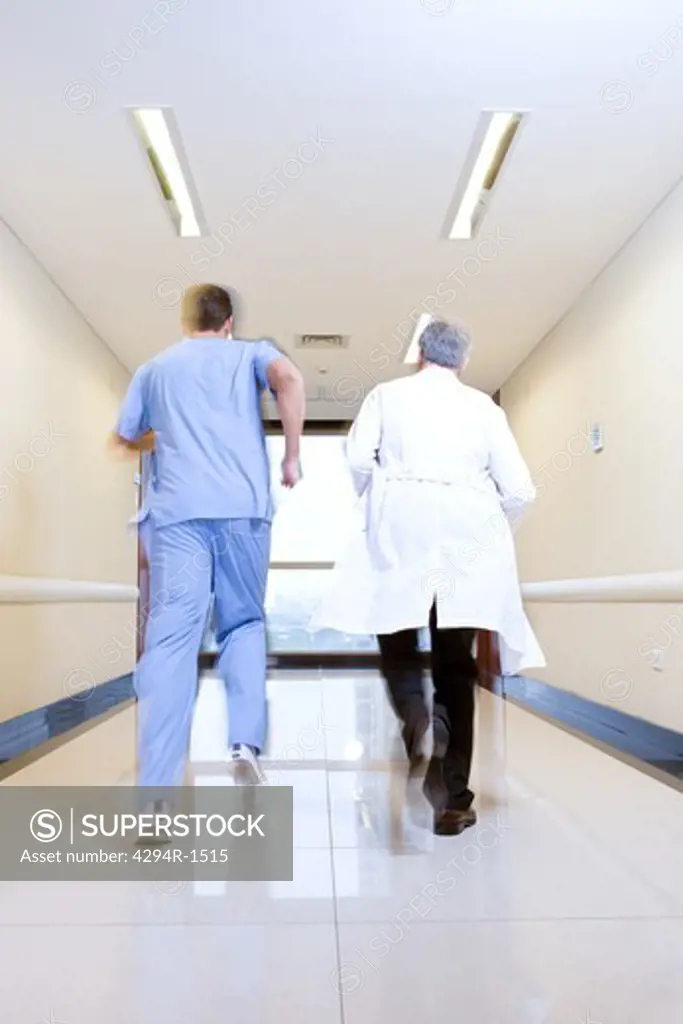 Two doctors running down hospital corridor