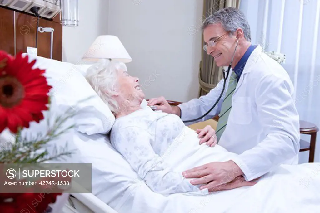 Doctor and senior woman in hospital bed