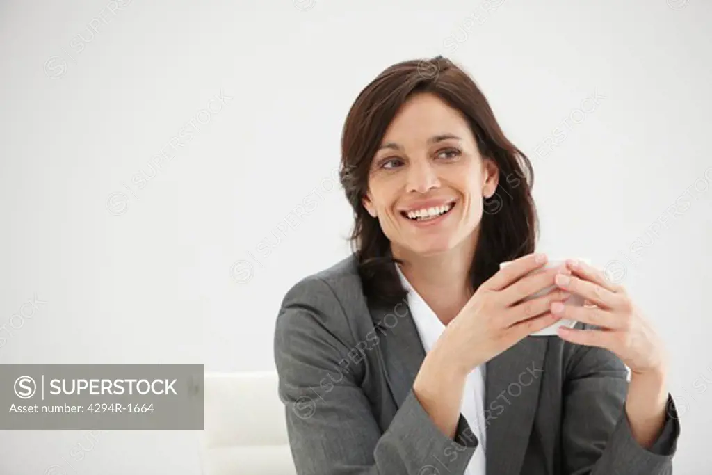 Confident businesswoman holding cup of coffee