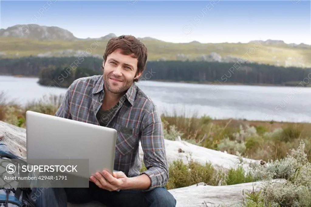 Man using laptop in remote landscape