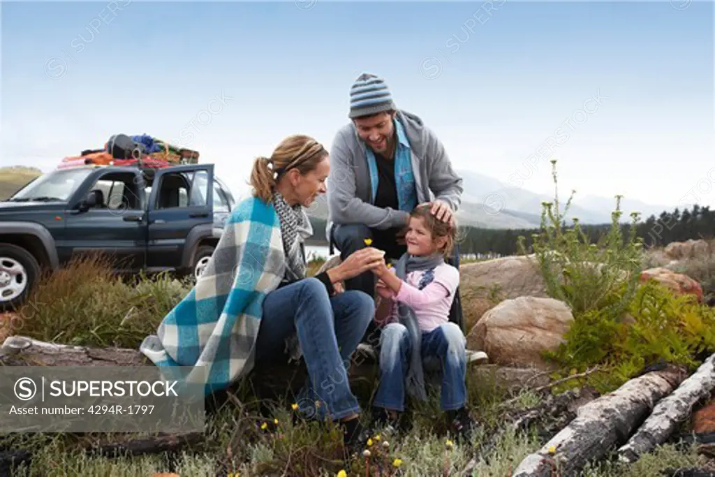 Daughter giving mother flower in remote landscape