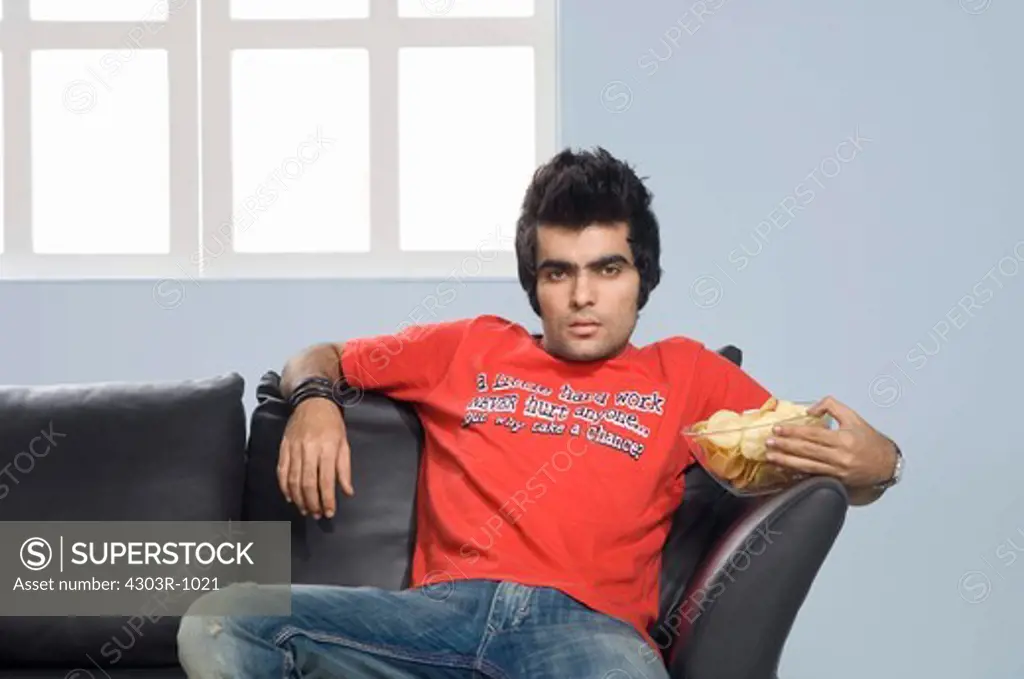 Young man holding bowl of wafer, portrait