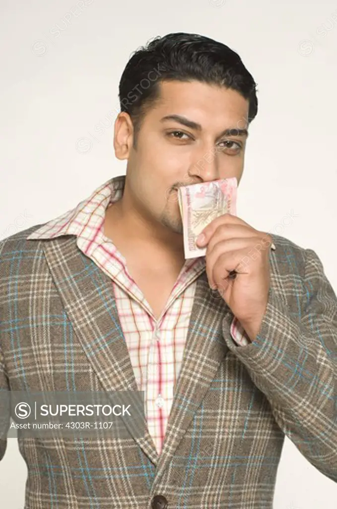 Mid adult man kissing paper currency, portrait
