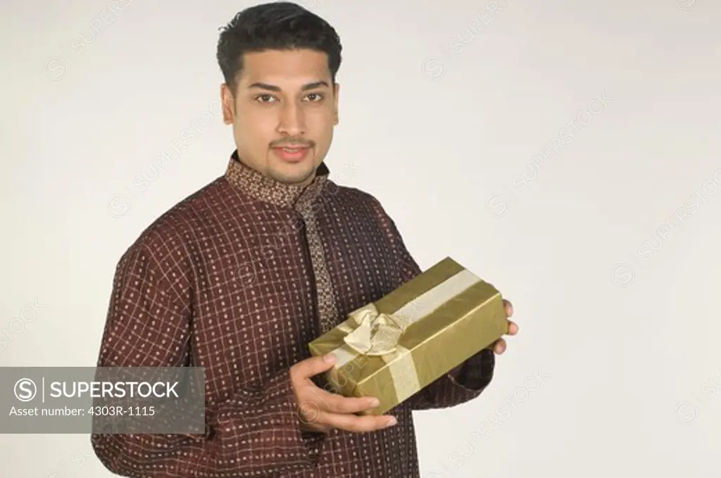 Mid adult man holding gift,portrait