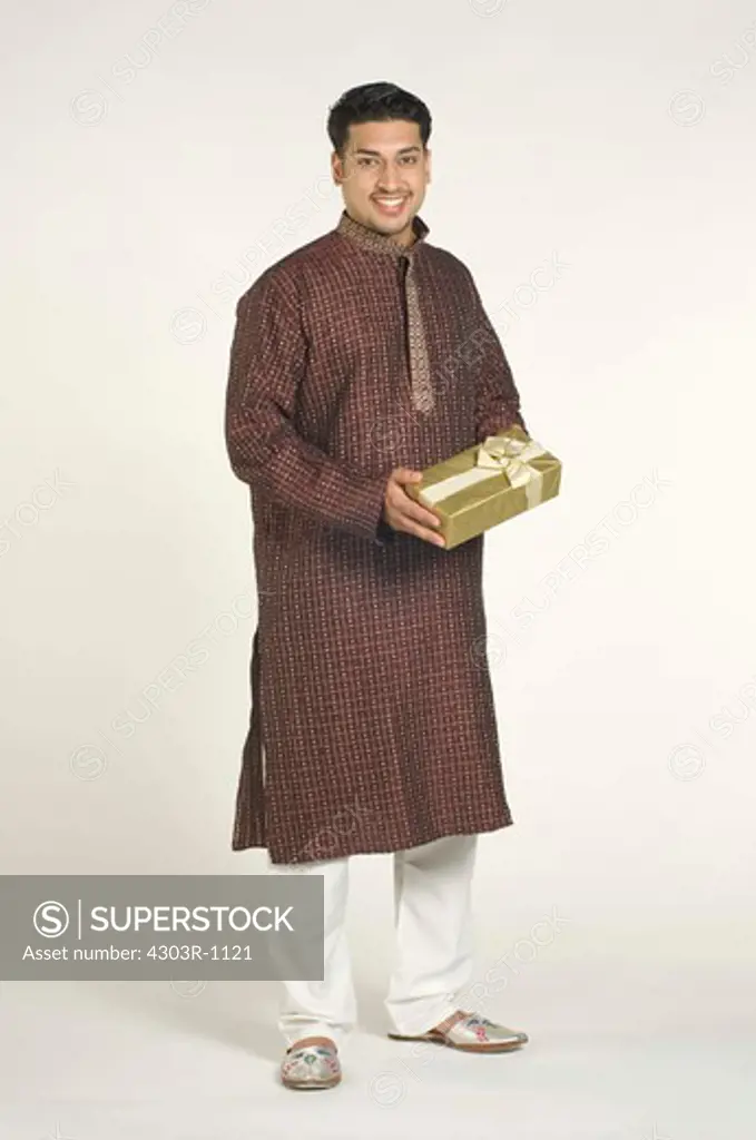 Mid adult man holding gift,smiling,portrait