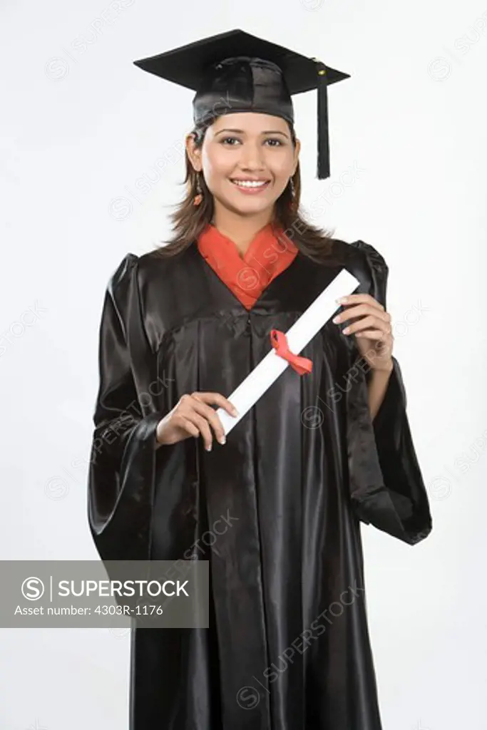 Young woman in academic regalia holding scroll, smiling, portrait