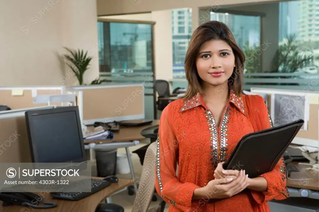Businesswoman holding folder in office,smiling,portrait