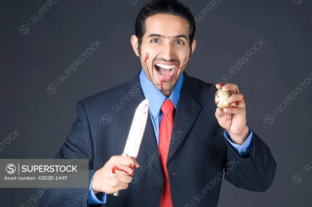 Businessman holding knife with golden egg, portrait, smiling