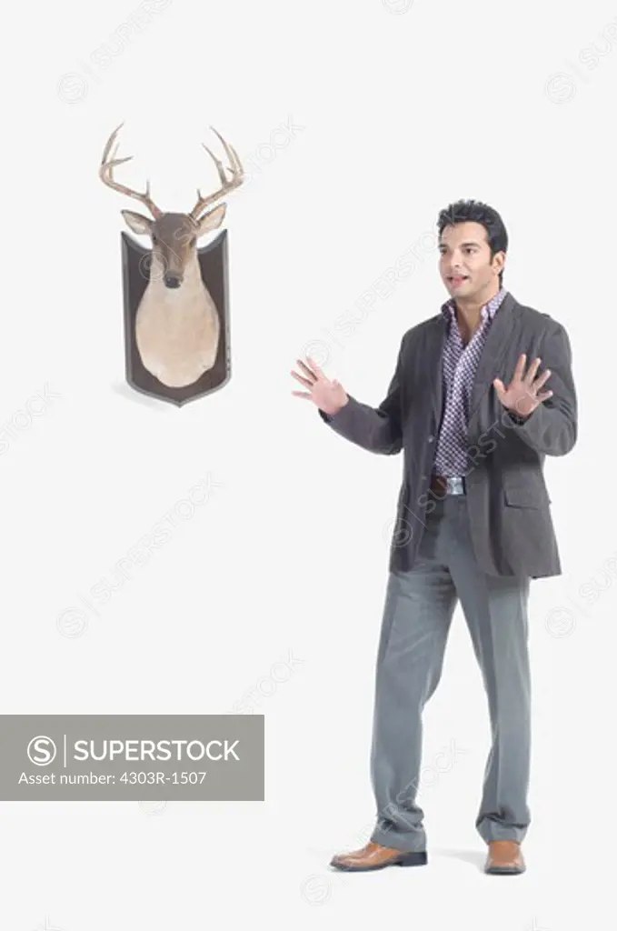 Young man standing by deer head