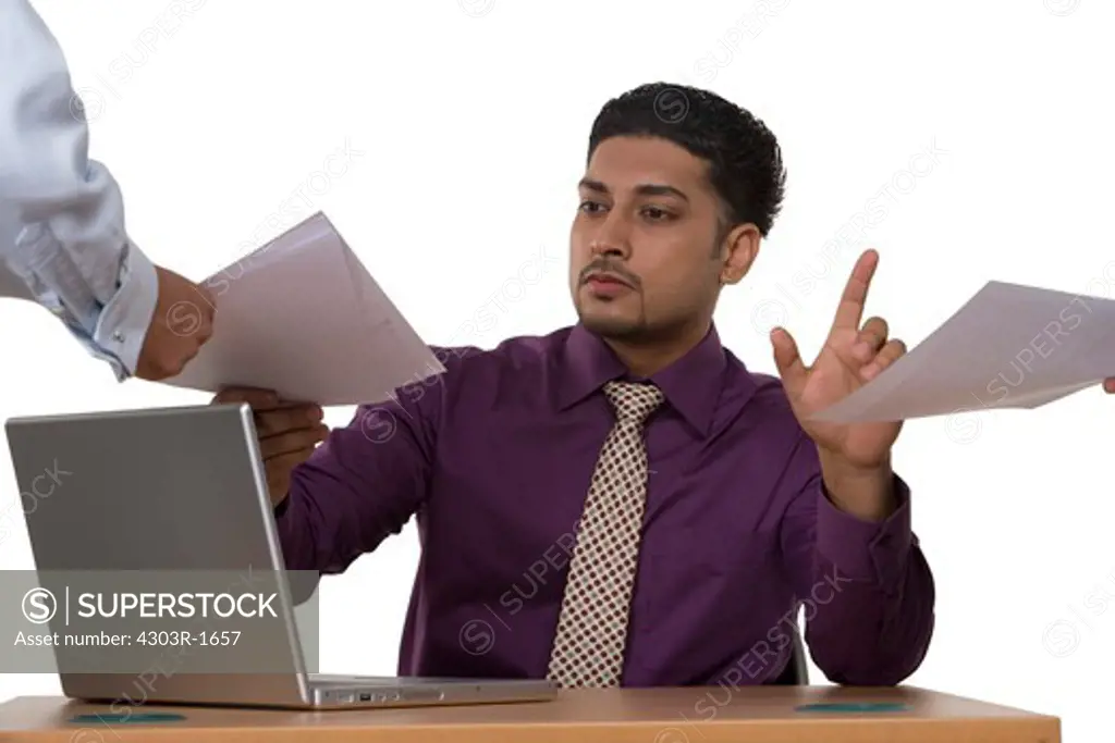 Businessman with laptop taking documents