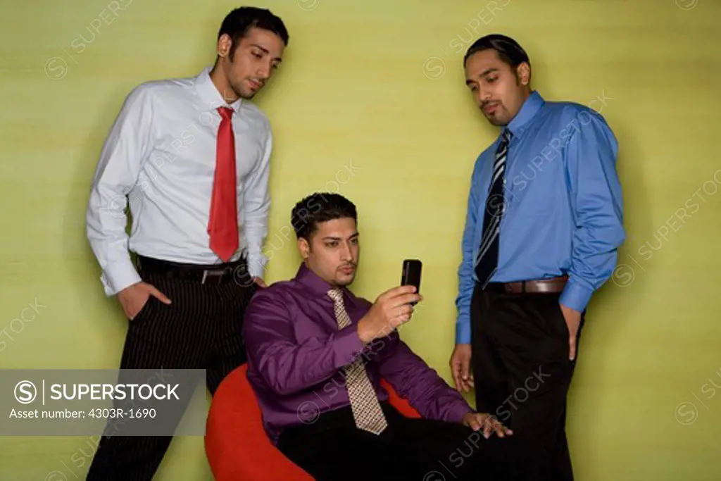 Colleagues looking at businessman sitting on swivel chair
