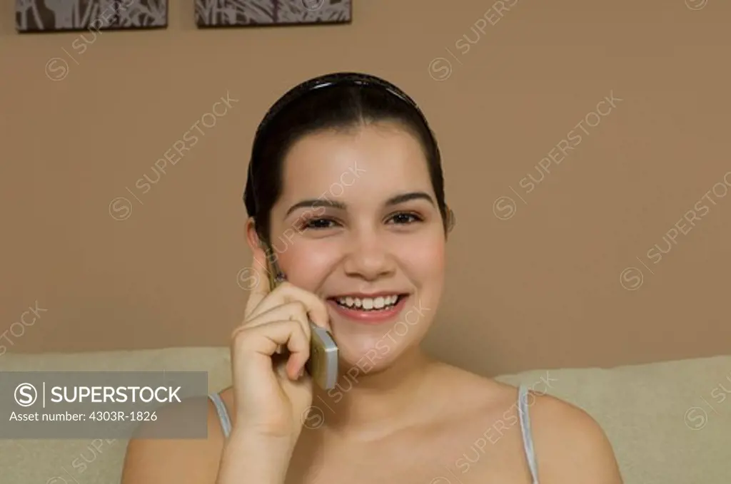 Teenage girl using mobile phone, smiling, portrait