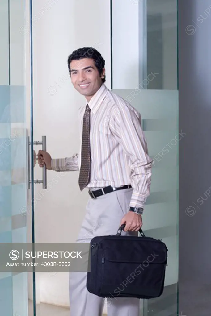 Businessman entering a room, holding a suitcase