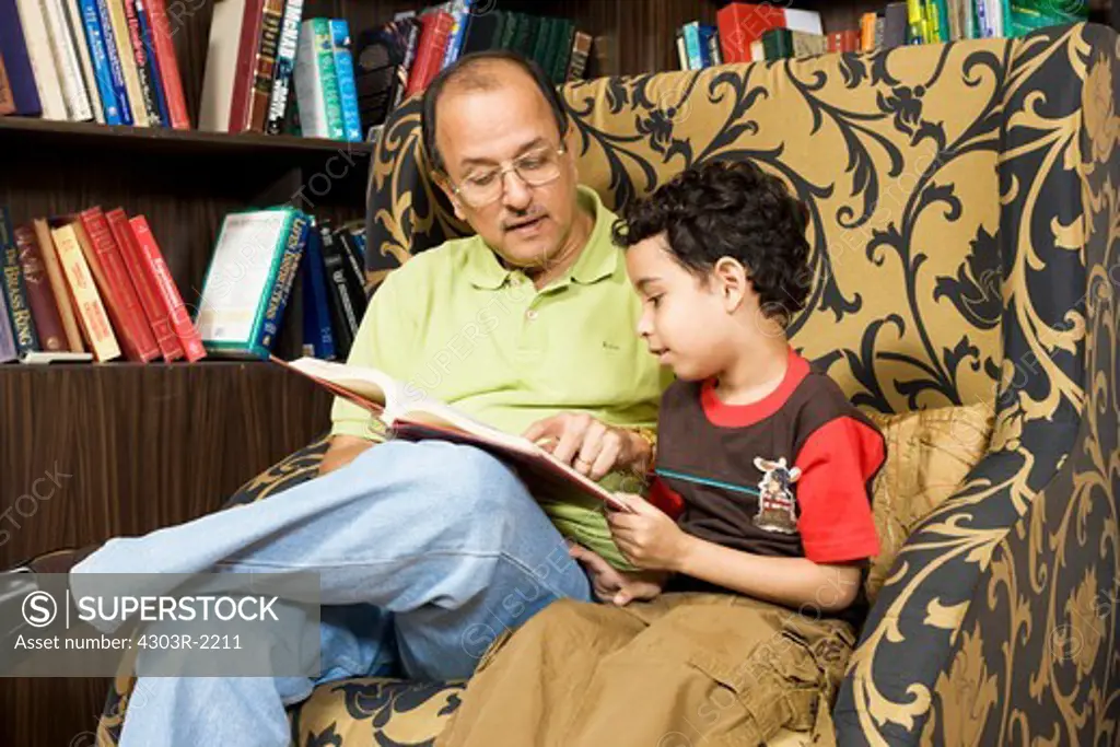 Grandfather with his grandson reading a storybook