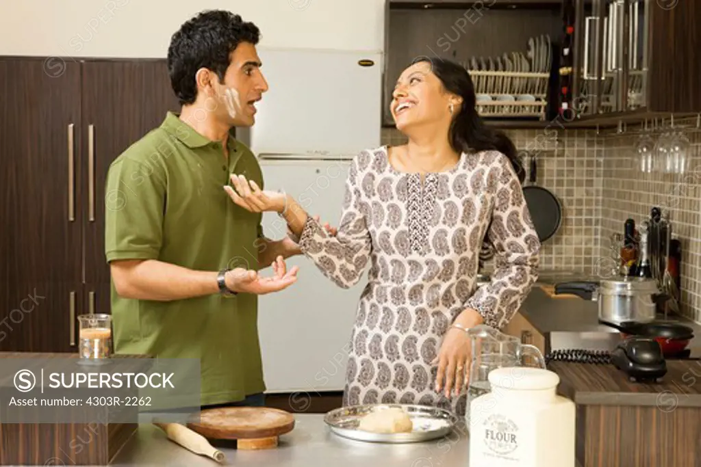 Couple playing with flour in the kitchen