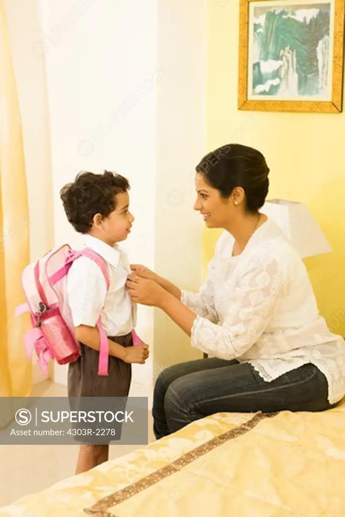 Mother helping her son to get ready for school