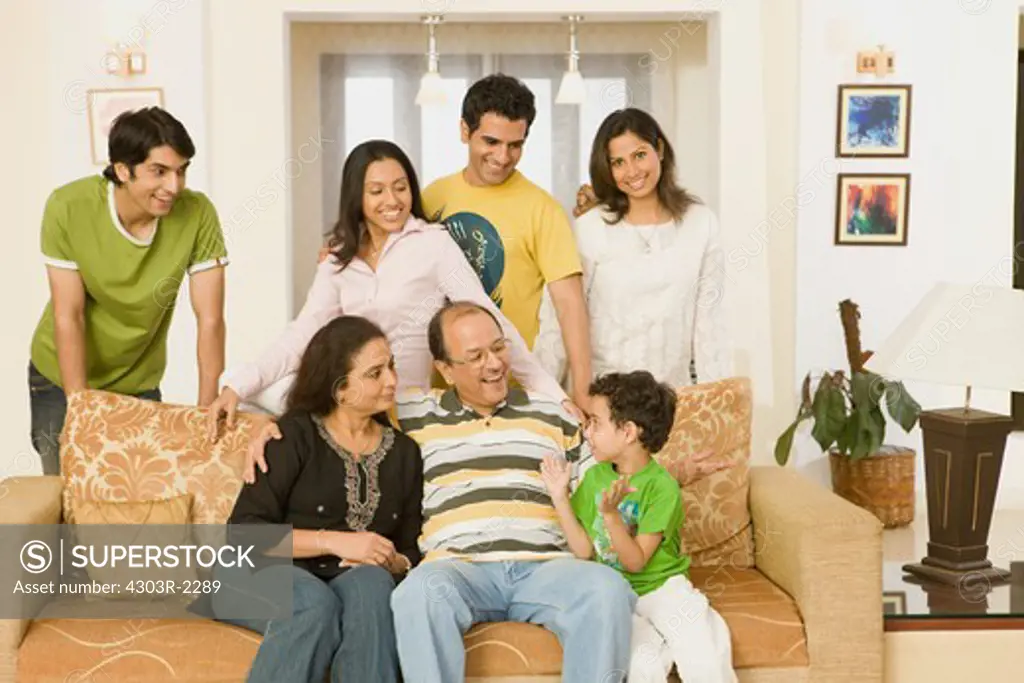 Three generation family sitting in the living room, smiling