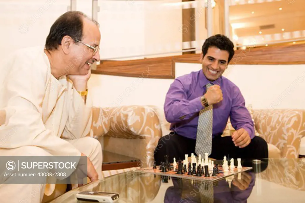 Father and son chess match in the living room