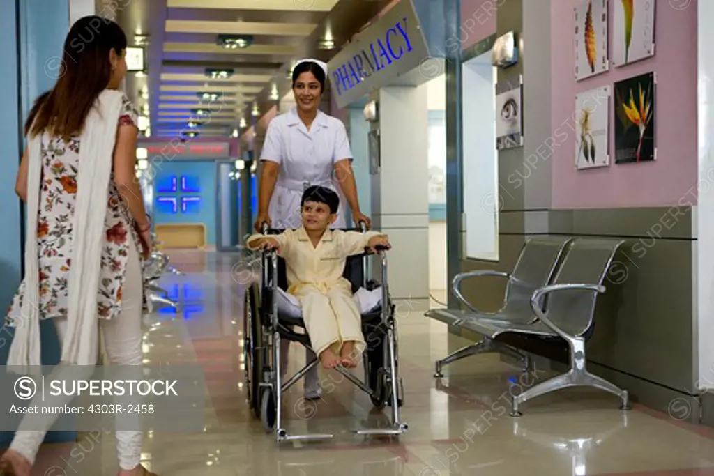 Mother visiting her son in a hospital, boy sitting on a wheelchair
