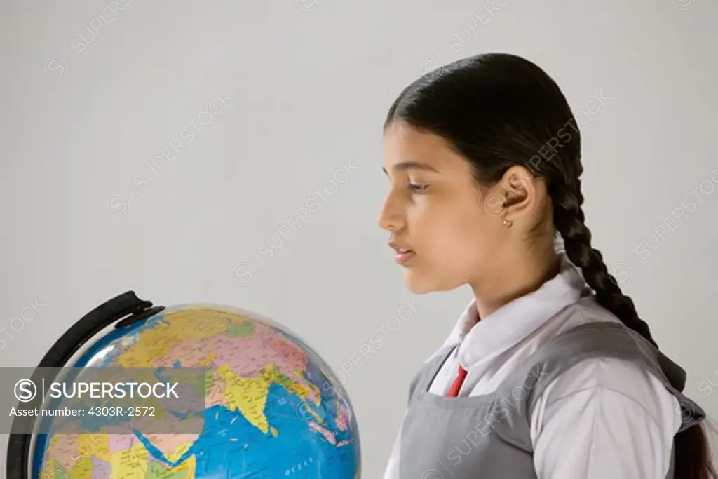 One school girl looking at globe