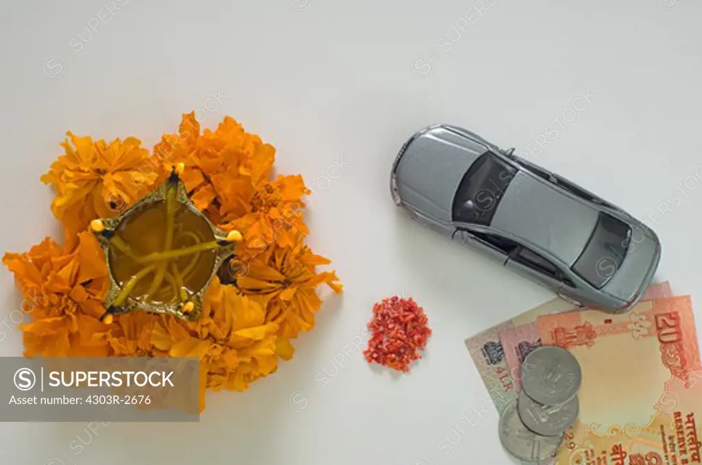 Traditional indian offerings with toy car and indian rupees