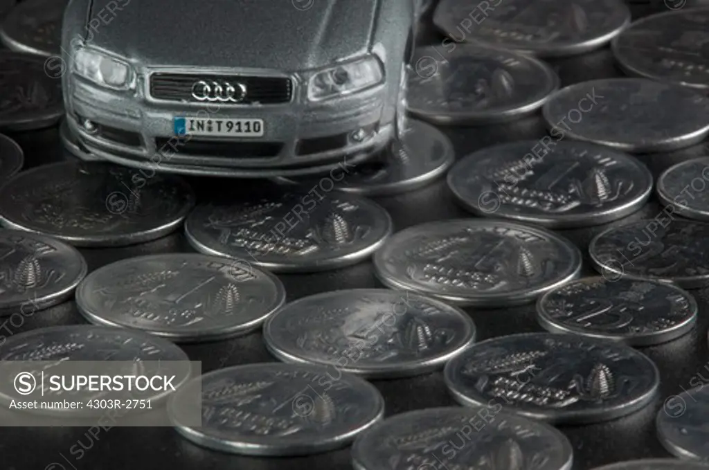 Toy car on top of indian rupee coins
