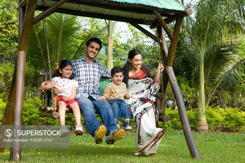 Family sitting on the swing in their garden