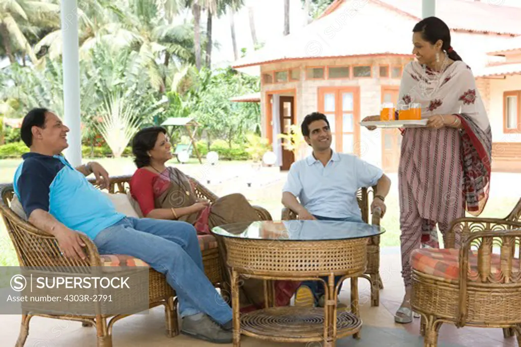 Woman serving juice to her family