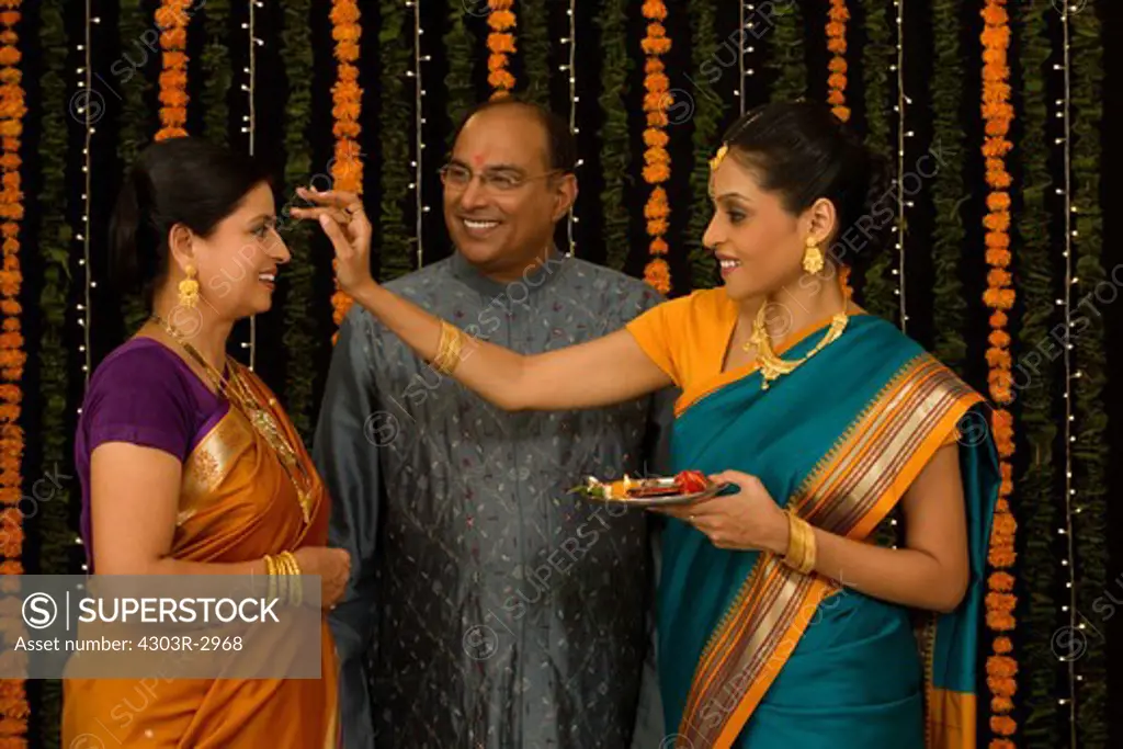Daughter putting bindi to her parents