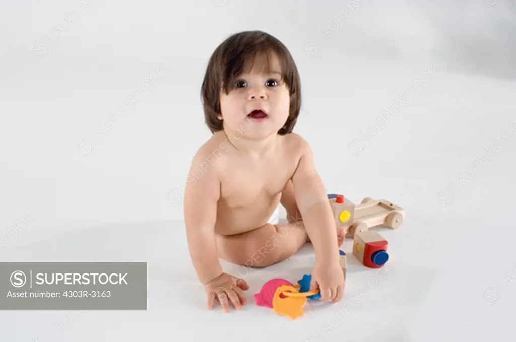 Baby boy sitting playing with toys