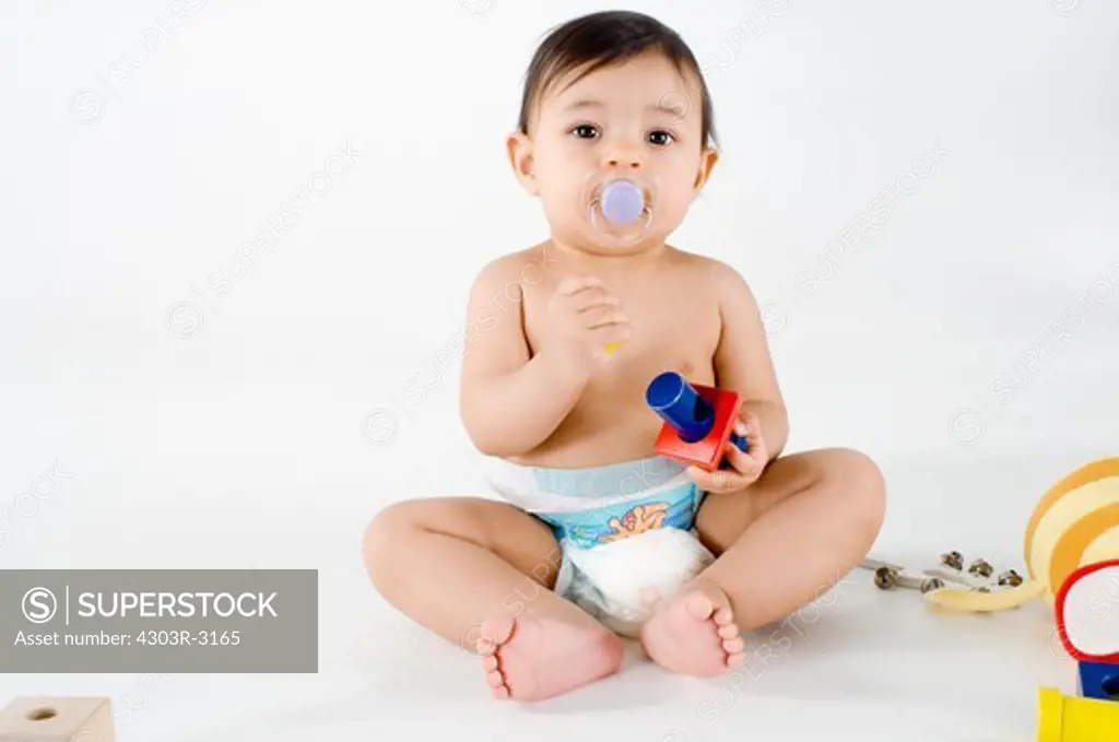 Baby girl sitting playing with toys