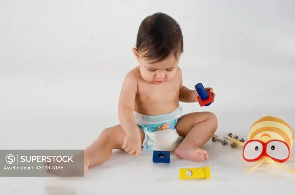 Baby girl sitting playing with toys