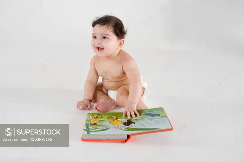 Baby boy with book, smiling