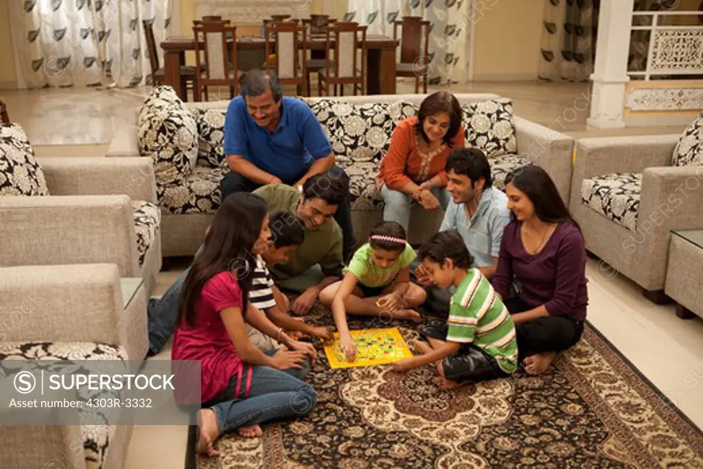 Three generation family playing scrabble in the living room