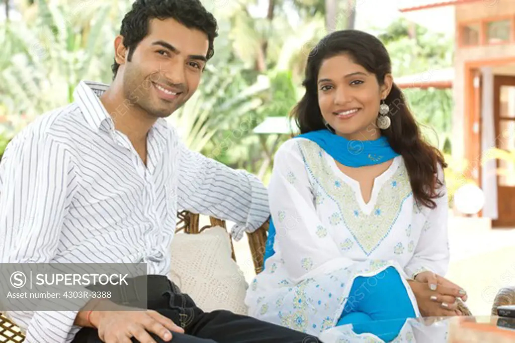 Couple sitting in the garden, smiling
