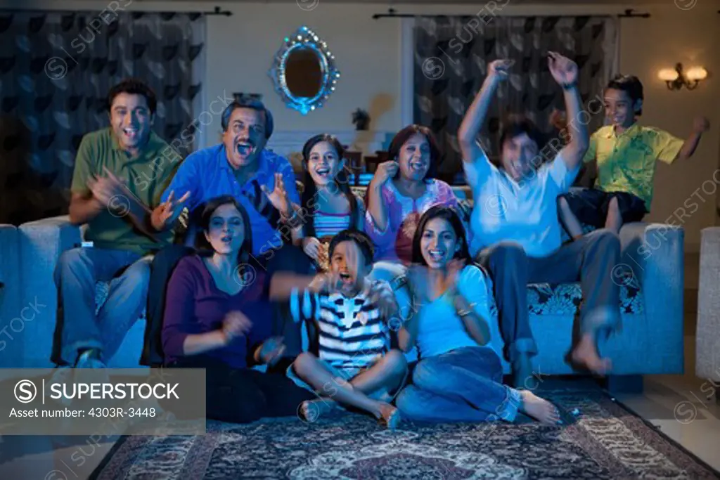 Three generation family watching television, cheering