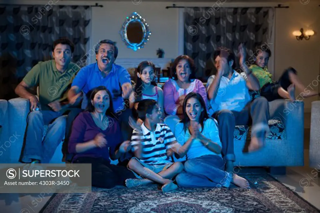 Three generation family watching television, cheering