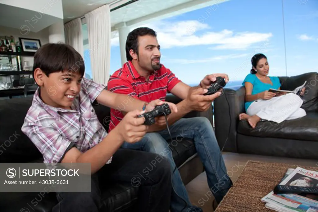 Father and son playing video game, mother watching.