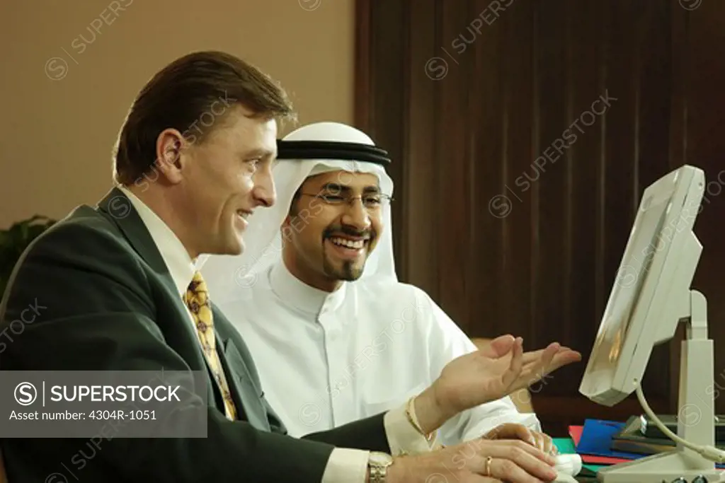 Businessmen having a discussion in front of a computer