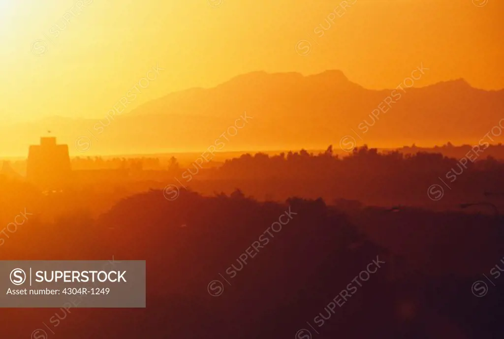 A spectacular view of mountains and trees seen during sunset.