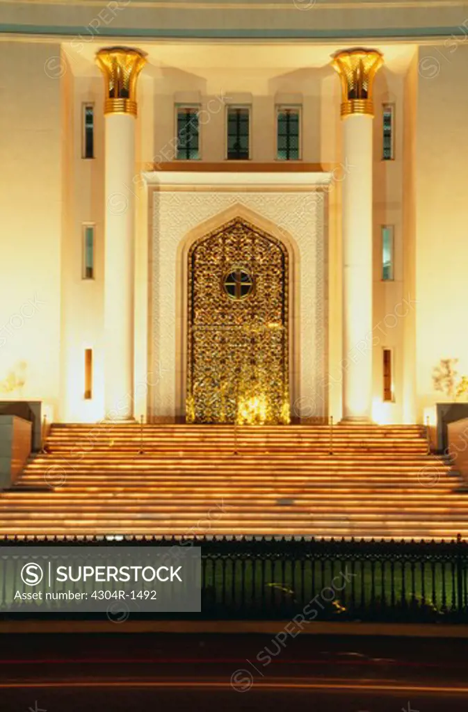 Front view of an elegant Oman National bank by night with pillars on either side of the door
