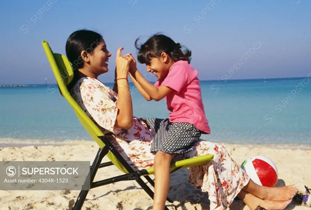 A mother and daughter cherishing happy moments on the beach.