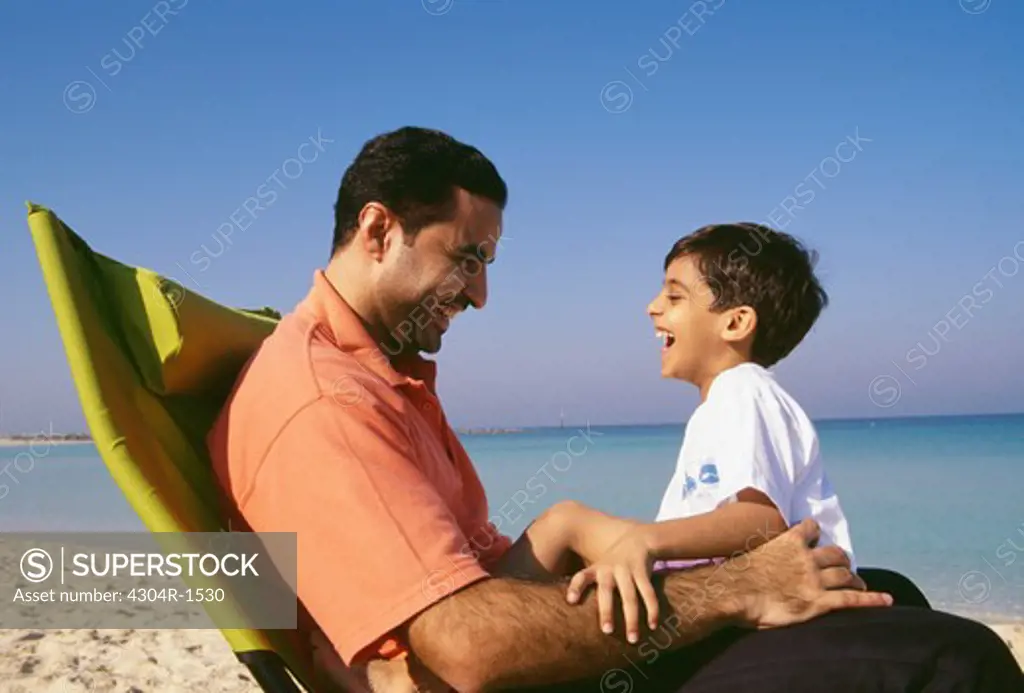 A father and son cherishing happy moments on the beach.