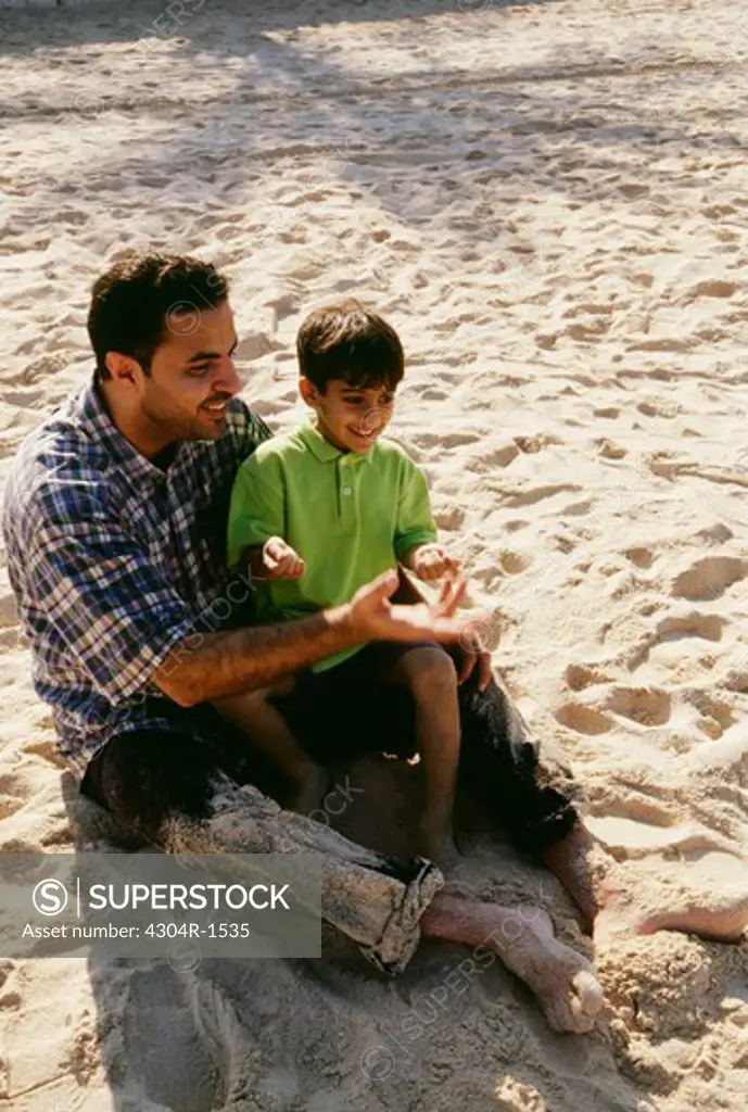 A father and a son enjoying themselves on the beach.