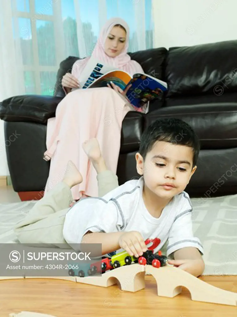 Kids are playing while Mother read the magazine