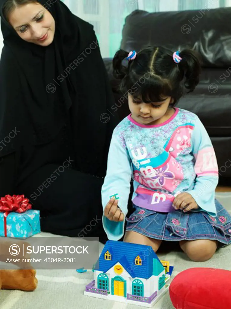 Arab mother watch her daughter while playing